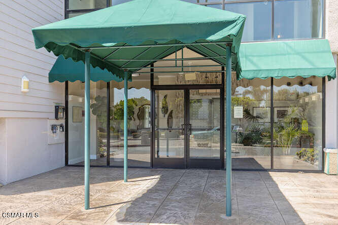 2901 Peninsula Road, Unit 348 Oxnard, CA 93035 - Photo 3 of 22 a patio with a table and chairs under an umbrella