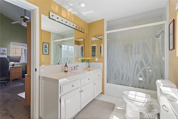 a spacious bathroom with a double vanity sink toilet mirror and bathtub