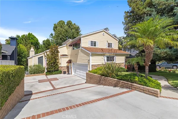 a front view of a house with a yard and potted plants