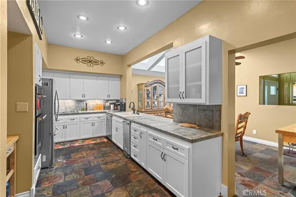 a kitchen with granite countertop white cabinets and white appliances