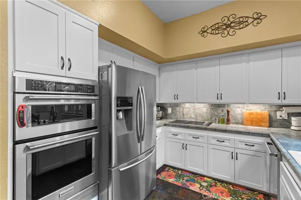 a kitchen with granite countertop white cabinets stainless steel appliances and sink