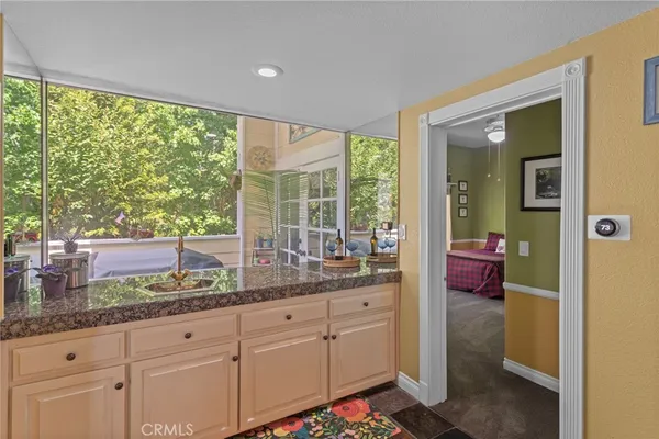 a very nice looking room with a large window and cabinets