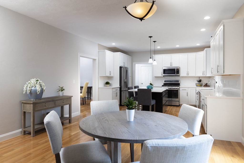 1 Pine House Road Millis, MA 02054 - Photo 5 of 33 a kitchen with stainless steel appliances kitchen island granite countertop a dining table chairs and a refrigerator