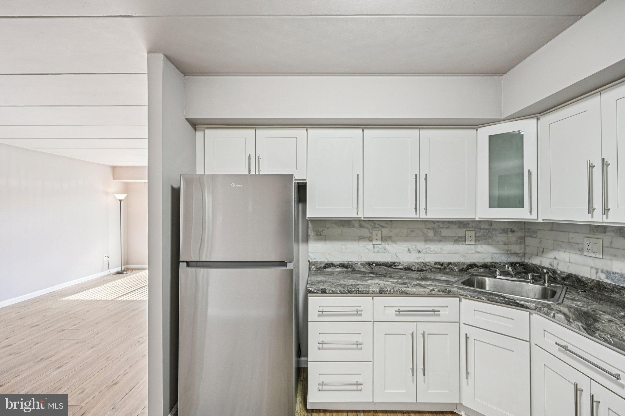9906 Bustleton Avenue, Unit C25 Philadelphia, PA 19115 - Photo 10 of 26 a kitchen with granite countertop a refrigerator sink and cabinets