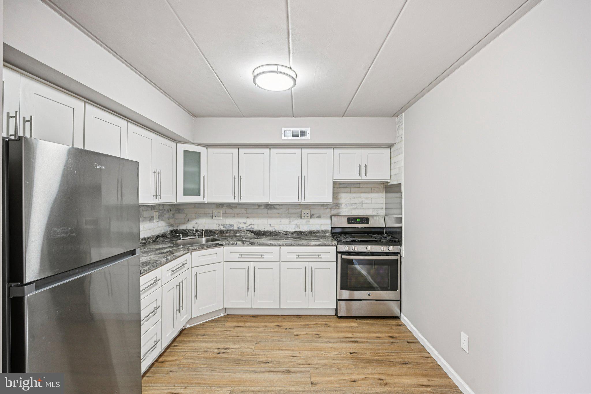 9906 Bustleton Avenue, Unit C25 Philadelphia, PA 19115 - Photo 12 of 26 a kitchen with stainless steel appliances granite countertop a stove and a refrigerator