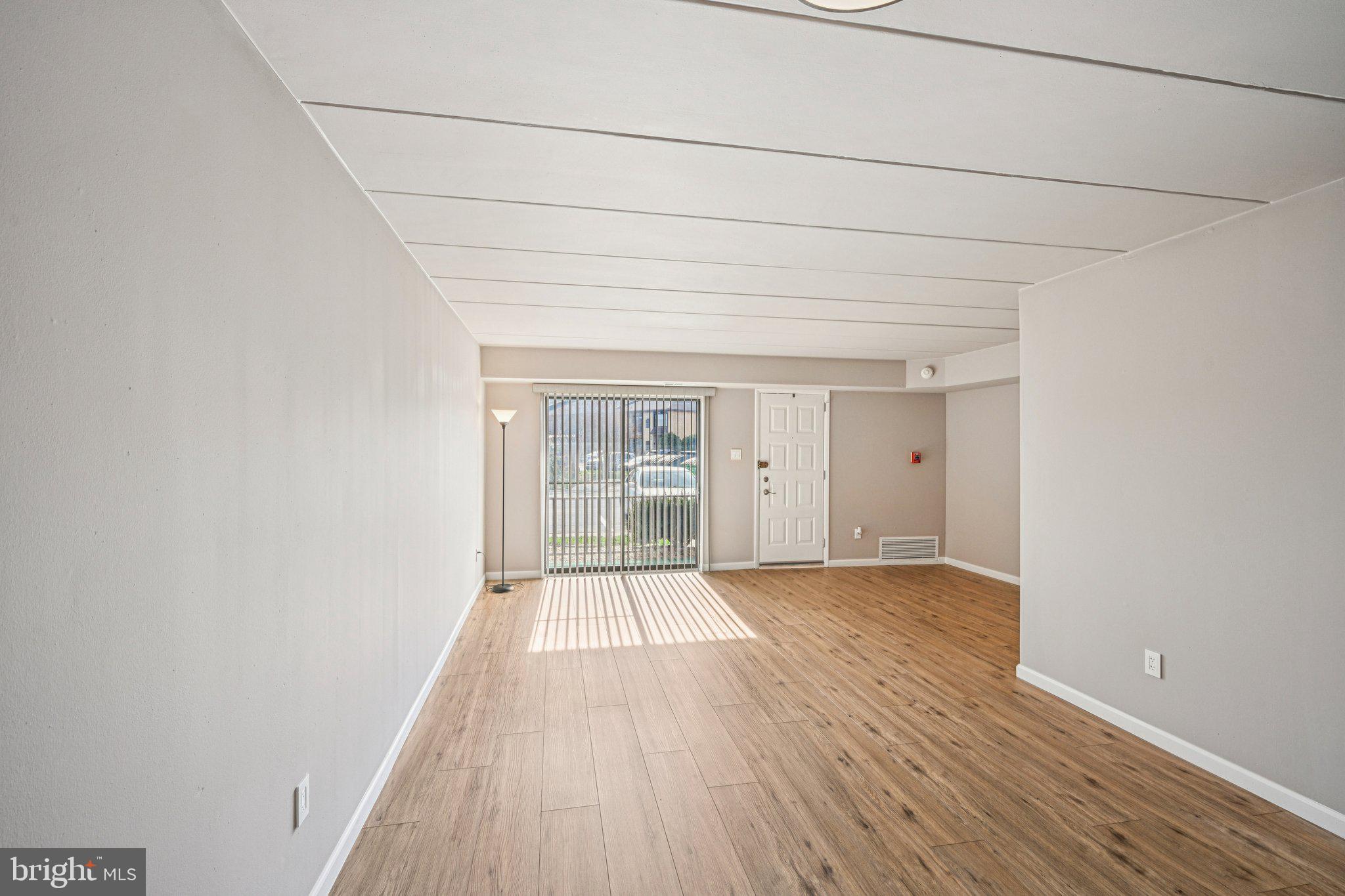 9906 Bustleton Avenue, Unit C25 Philadelphia, PA 19115 - Photo 8 of 26 a view of an empty room with wooden floor and a window