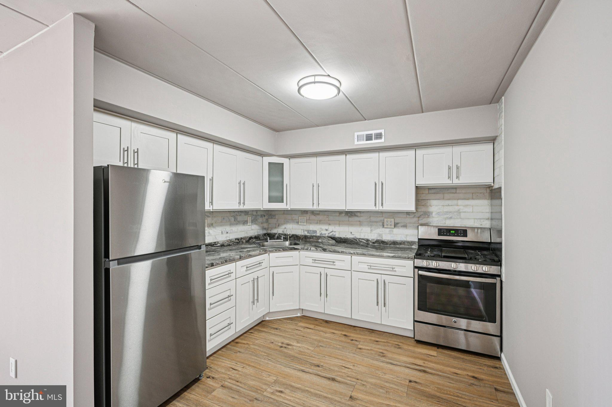 9906 Bustleton Avenue, Unit C25 Philadelphia, PA 19115 - Photo 9 of 26 a kitchen with a sink stove and refrigerator