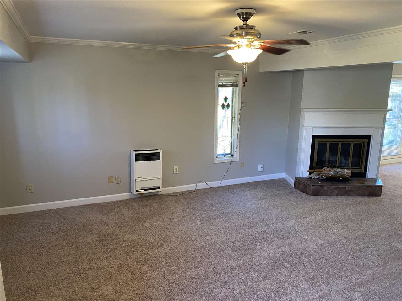 198 South Walnut Bend Road Memphis, TN 38018 - Photo 2 of 18 a view of a livingroom with a fireplace a chandelier fan and windows