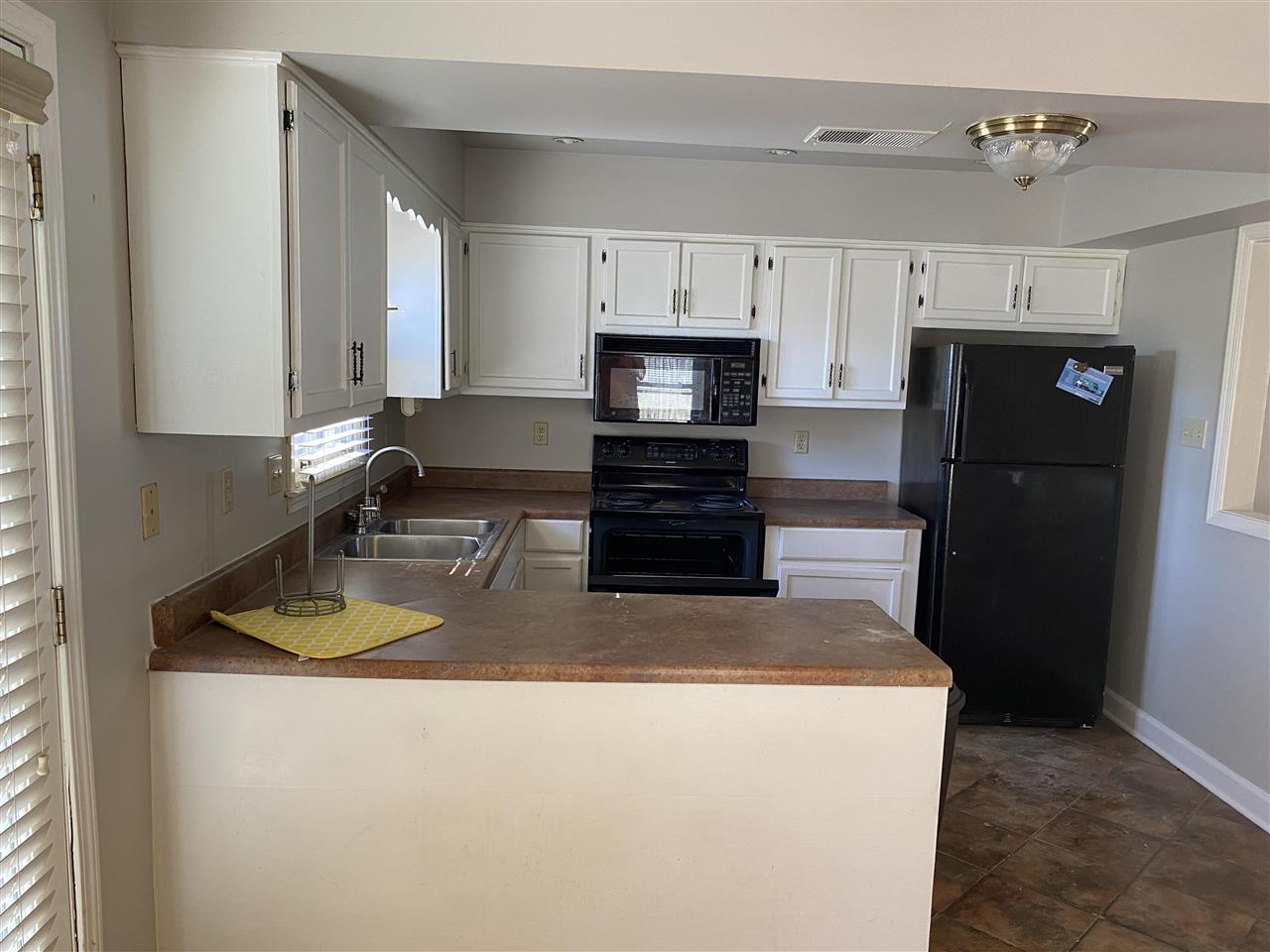 198 South Walnut Bend Road Memphis, TN 38018 - Photo 6 of 18 a kitchen with kitchen island a refrigerator a stove a microwave and cabinets