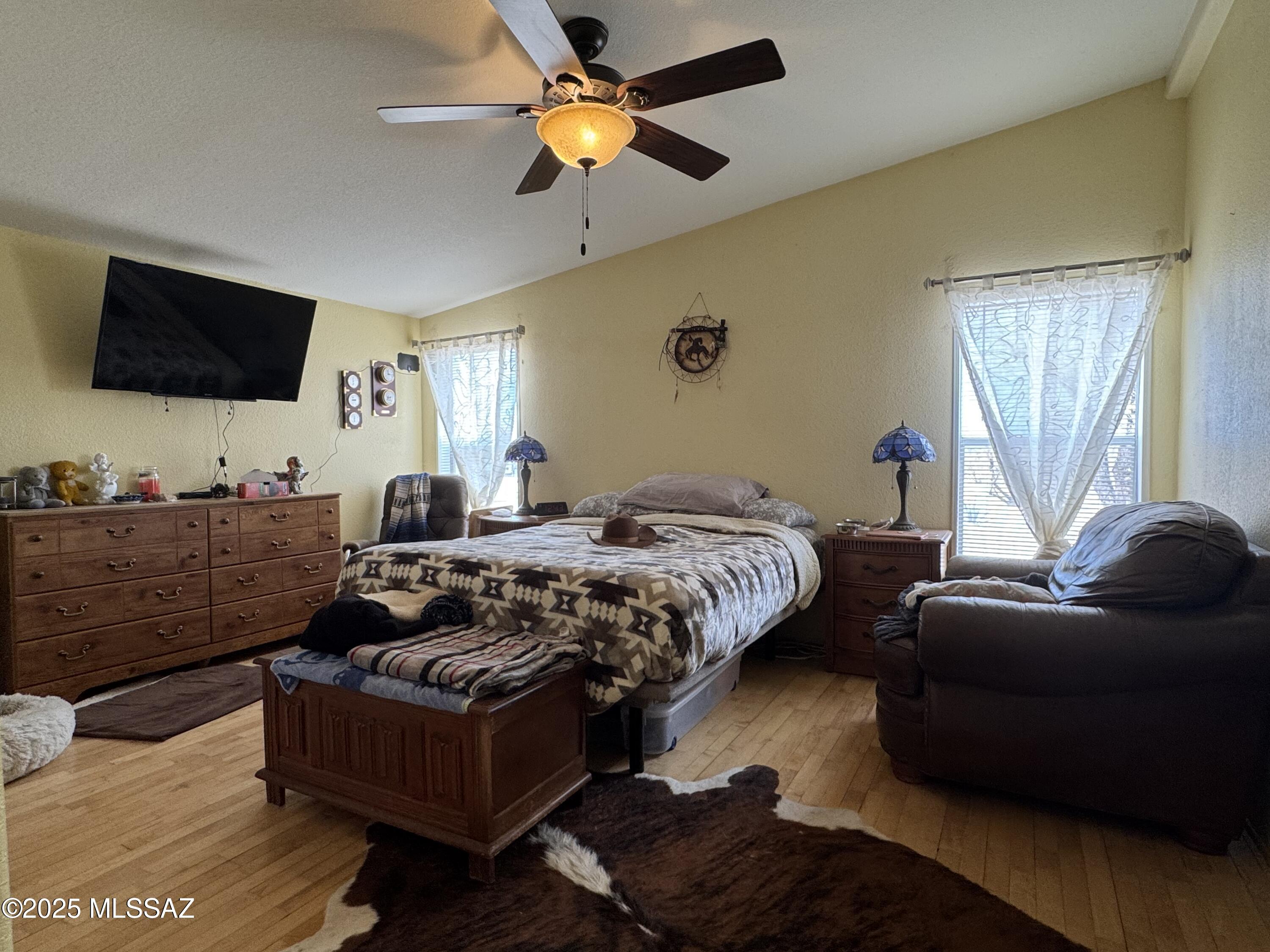 12440 South Coleman Road Tucson, AZ 85735 - Photo 30 of 45 a bedroom with a bed a couch and a flat screen tv