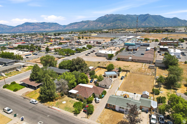 5480 South 2000th Street West Roy, UT 84067 - Photo 32 of 36 Aerial view of a residential street with mature trees and a distant mountain range