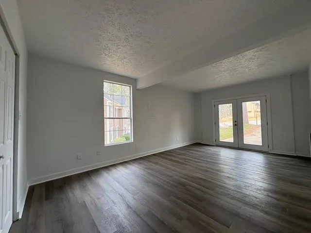 an empty room with wooden floor and window