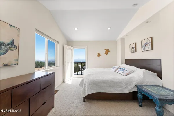 a bedroom with a large bed and paintings on the wall