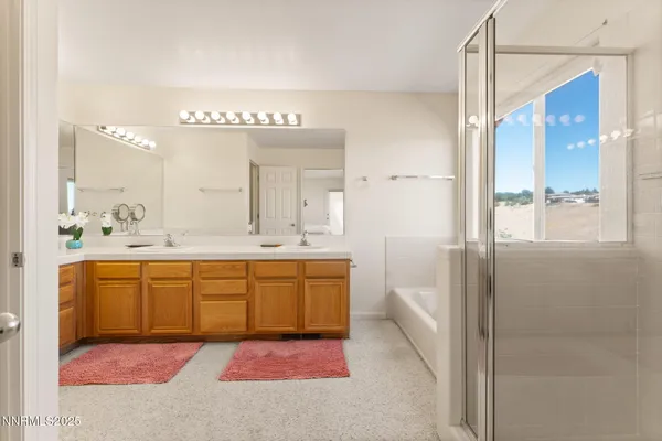 a spacious bathroom with a double vanity sink a mirror and a bathtub