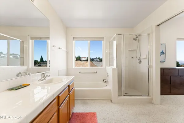 a bathroom with a tub sink shower and a mirror