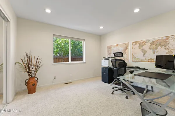 a view of a workspace with furniture and a window
