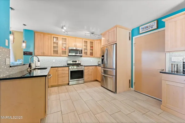 a kitchen with stainless steel appliances granite countertop a refrigerator sink and stove