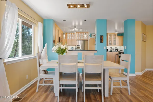 a dining room with furniture a floor to ceiling window and wooden floor