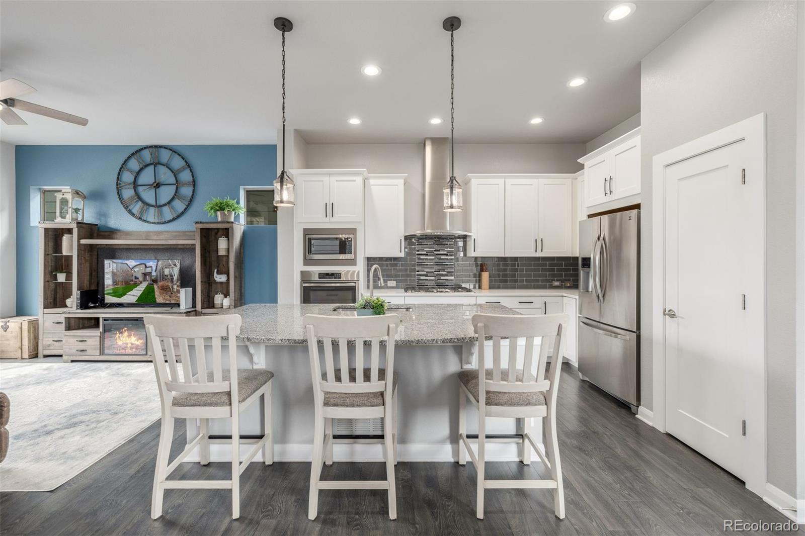6777 Larsh Drive Denver, CO 80221 - Photo 2 of 48 a kitchen with stainless steel appliances kitchen island granite countertop a dining table chairs and white cabinets