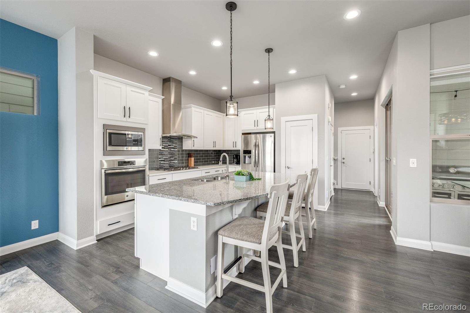 6777 Larsh Drive Denver, CO 80221 - Photo 9 of 48 a kitchen with stainless steel appliances kitchen island granite countertop a refrigerator and a stove top oven