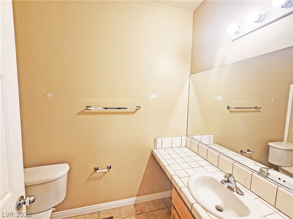 1421 Star Road, Unit 2 Pahrump, NV 89048 - Photo 20 of 33 Bathroom with baseboards, tile patterned floors, vanity, and toilet