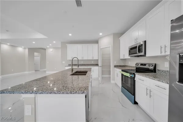 a kitchen with stainless steel appliances granite countertop a sink and a stove