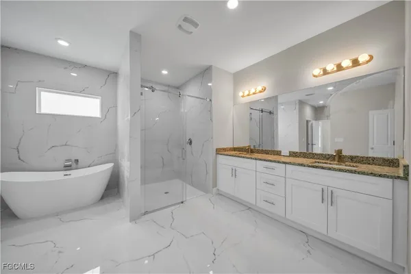 a bathroom with a granite countertop sink a large mirror and shower