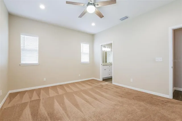 an empty room with windows and fan