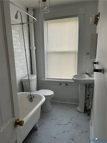 a bathroom with a tub sink and mirror