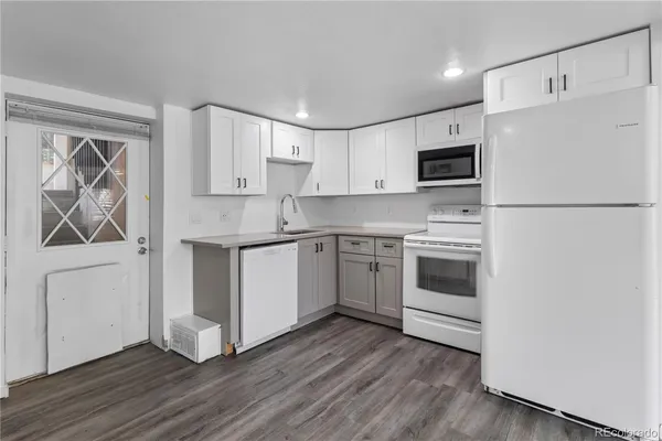 a kitchen with white cabinets white stainless steel appliances and sink