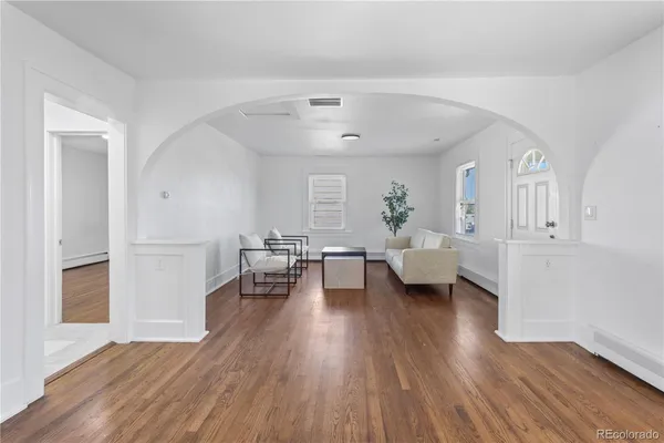 a living room with furniture and a wooden floor