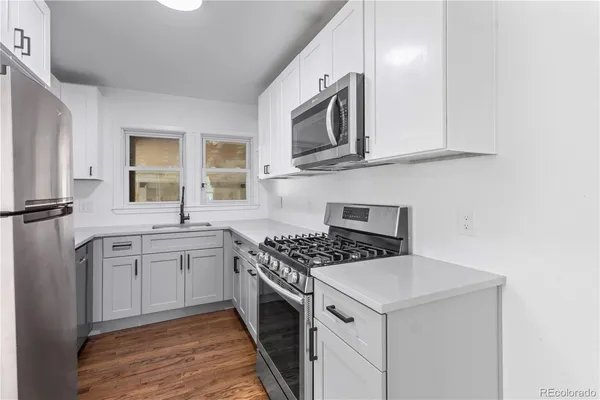 a kitchen with stainless steel appliances granite countertop a stove a sink and a microwave