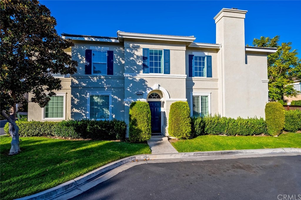 a front view of a house with a garden and plants