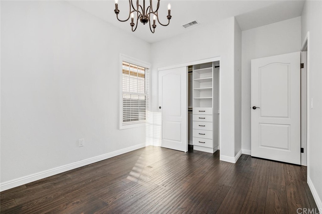 4350 Milano Way Oceanside, CA 92057 - Photo 18 of 30 an empty room with wooden floor closet and windows