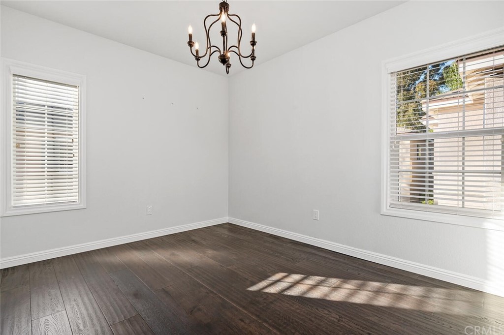 4350 Milano Way Oceanside, CA 92057 - Photo 19 of 30 an empty room with wooden floor and windows