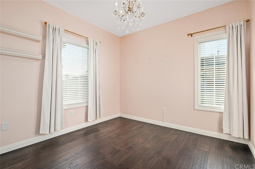 4350 Milano Way Oceanside, CA 92057 - Photo 20 of 30 an empty room with wooden floor chandelier and windows