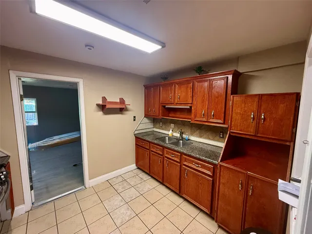 a kitchen with granite countertop a refrigerator stove top oven and sink