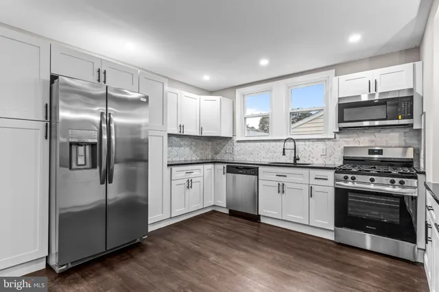 a kitchen with stainless steel appliances granite countertop a stove a refrigerator and a sink