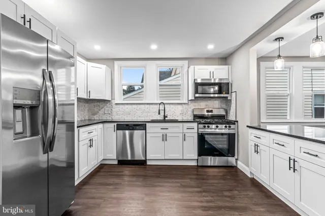 a kitchen with stainless steel appliances granite countertop a stove a sink and a refrigerator