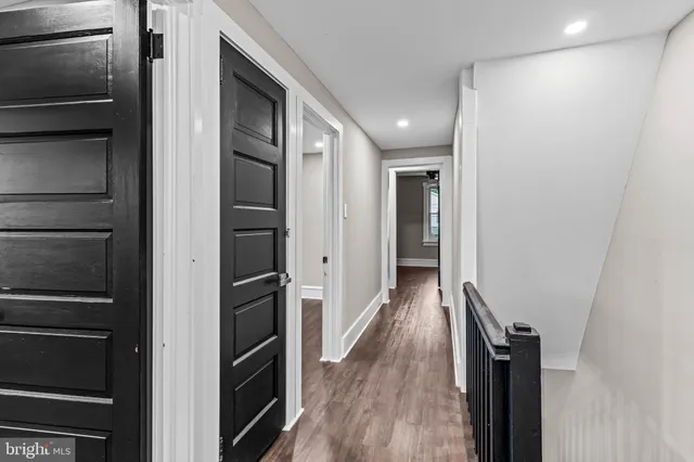 a view of hallway with stairs and wooden floor