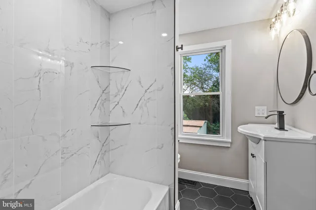 a bathroom with a sink a window and a shower