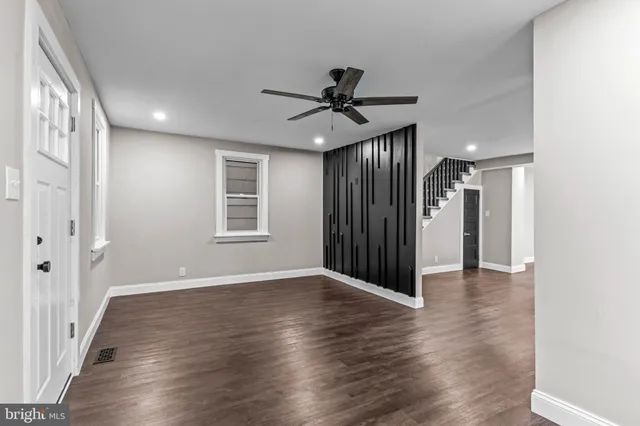 a view of a hallway with wooden floor and a ceiling fan