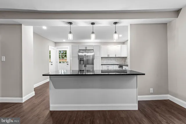 a kitchen with granite countertop a wooden floor and cabinets