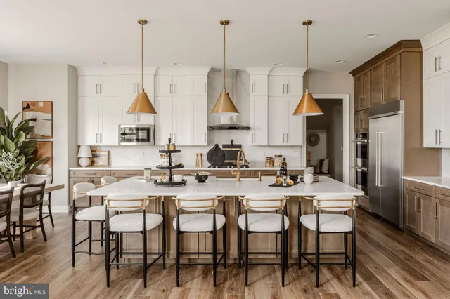 a view of a dining room and livingroom with furniture wooden floor a chandelier