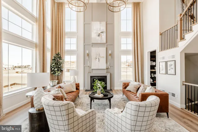 a living room with furniture fireplace and large windows