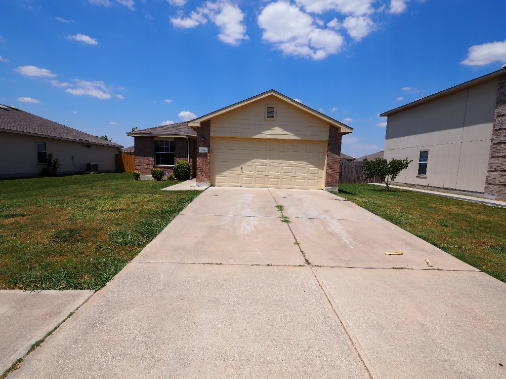 204 Phillips Street Hutto, TX 78634 - Photo 1 of 1 a front view of a house with garden