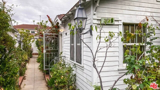 a view of path along with brick wall and potted plants