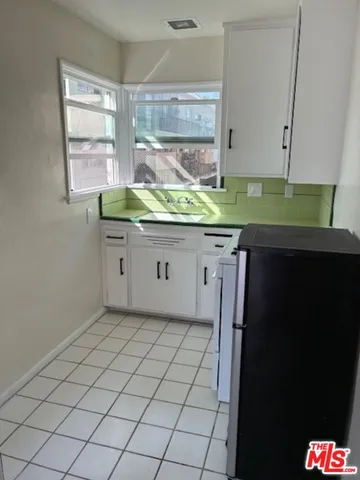 a kitchen with a sink a window and cabinets