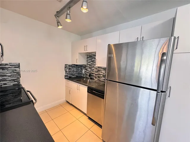 a kitchen with stainless steel appliances a refrigerator and a stove top oven