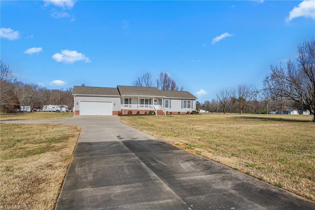 7021 Eaglesfield Road Gibsonville, NC 27249 - Photo 6 of 49 Long paved driveway to home and detached garage, offering generous parking options.